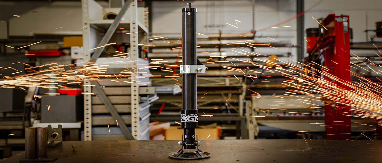 An AGM Manual Jack Pro, standing on a workbench in a workshop with sparks flying across the scene.