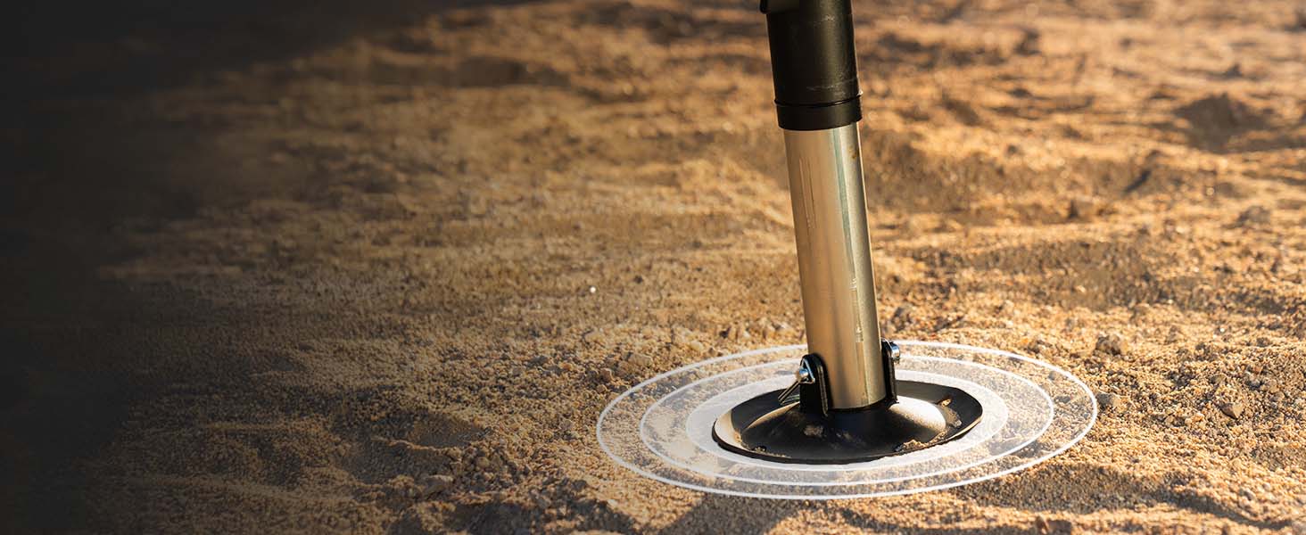 A close-up of AGMs patented GroundLoc Jack base pad, placed on a sandy surface.