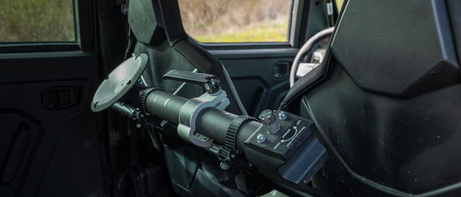 A AGM Manual Jack Sport mounted in AGM Quick Clamsp inside a car cabin, shown attached to a front seat cross bar. 