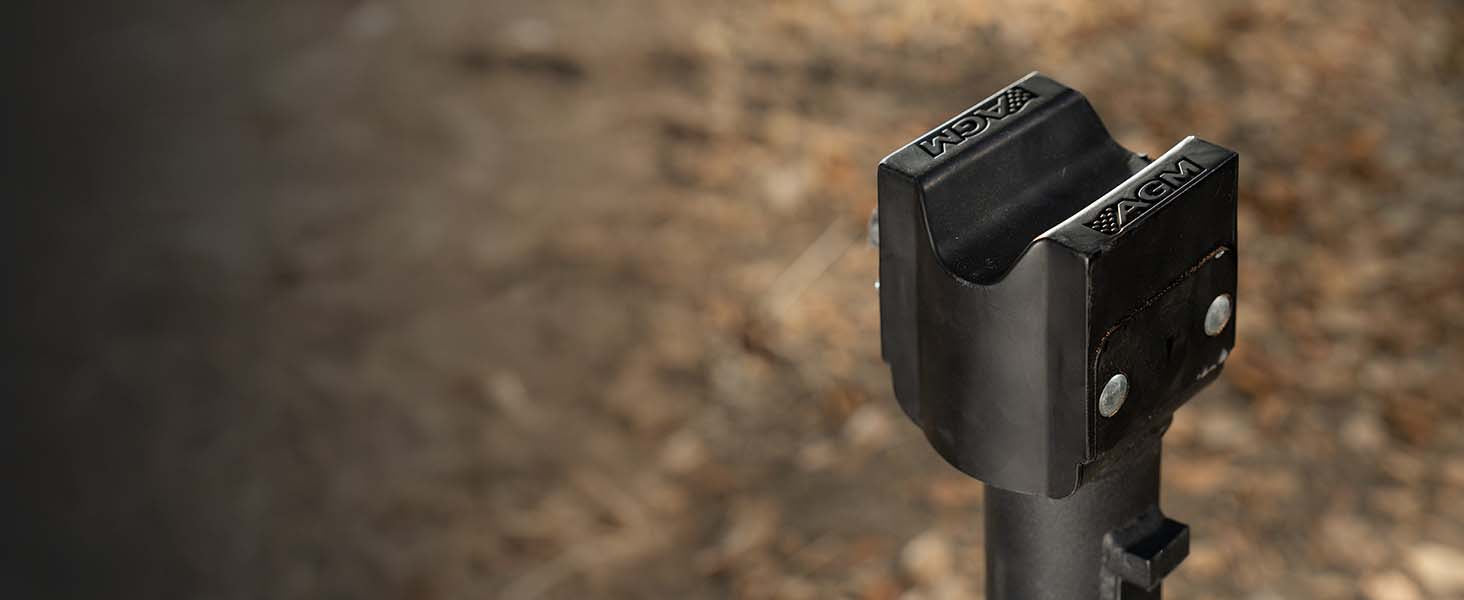 Close-up of AGMs patented V groove top cap on a Manual Jack sport, shown against a blurred outdoor background of dry leaves and dirt.